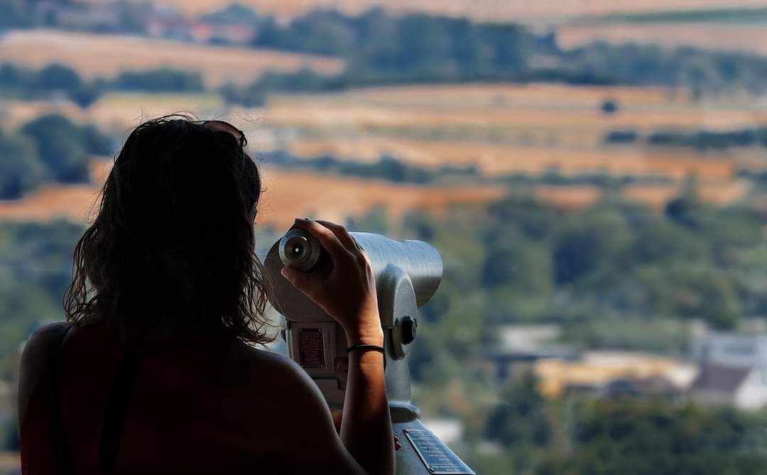 Eine Frau bewundert die Aussicht mit Fernglas